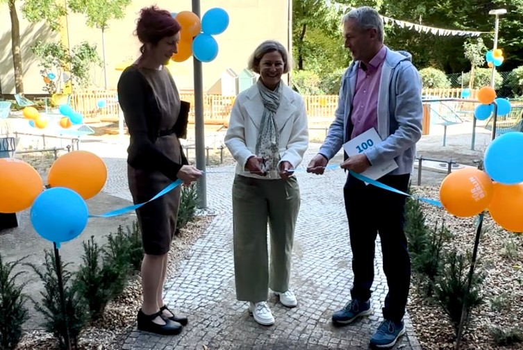 Ivette Grafe von der Firma "Strauchpoeten" und die Vorstände Angeliki Krisilion Dr. Hinrich Holm schneiden ein Band zur Eröffnung des kleines Parks vor der IBB durch.