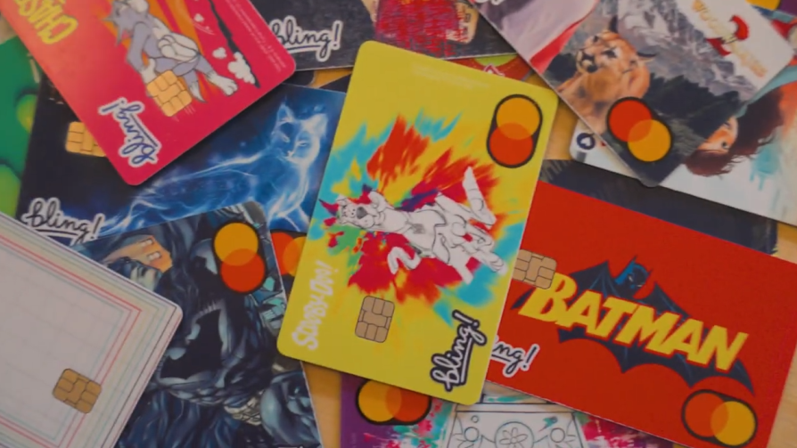 Mehrere bunte Bling-Prepaid-Karten mit verschiedenen Designs, darunter Scooby-Doo, Batman und weitere Comic-Motive, fächerförmig ausgebreitet